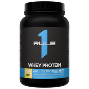 Black protein powder jar with a blue RULE 1 WHEY PROTEIN label and yellow Banana Creme flavor icon